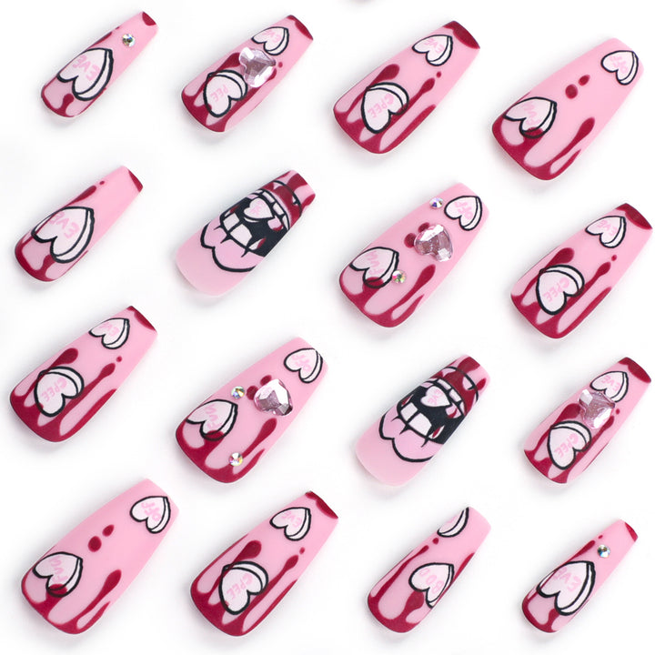 Kunstvolle Stiletto-Nägel mit Herzen und Glitzerakzenten Karnz
