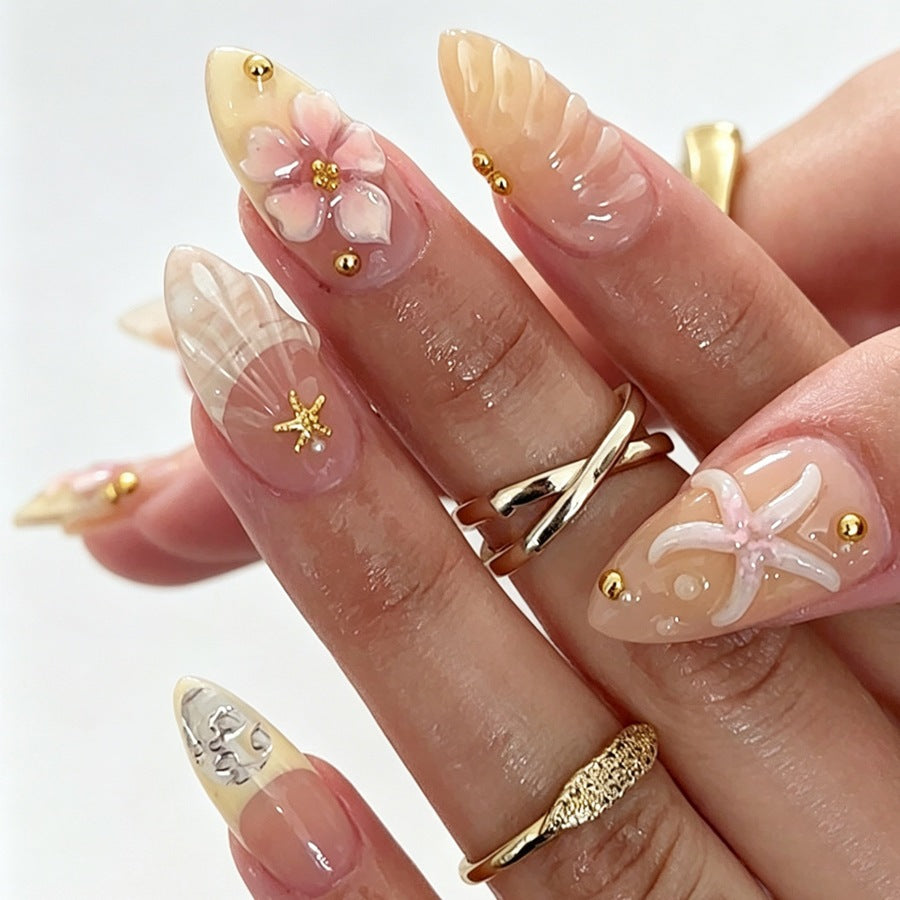 Kunstnagelset mit floralen 3D-Elementen und goldenen Akzenten Karnz