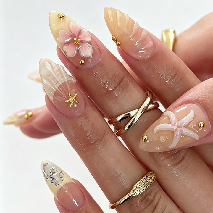Kunstnagelset mit floralen 3D-Elementen und goldenen Akzenten Karnz