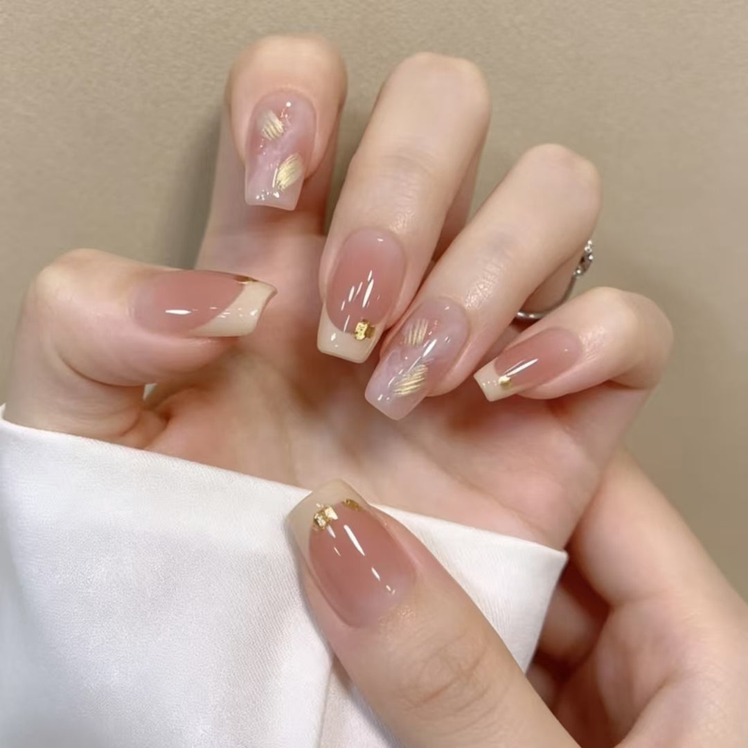 Elegante französische Nagelverlängerungen mit goldenen Akzenten