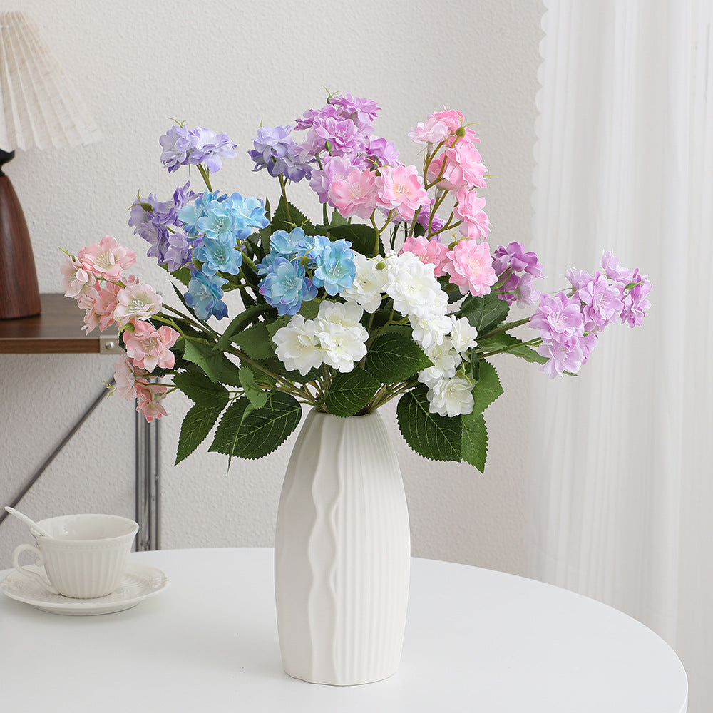 Kunstblumenarrangement mit zarten weißen Blüten Karnz