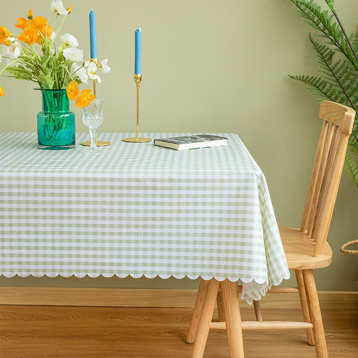 Runde abwaschbare Tischdecke mit feinem Karo‑Gittermuster und welligem Saum