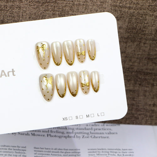 Elegante Press-On-Nagelkunst mit goldenen Schleifenzubehör Karnz