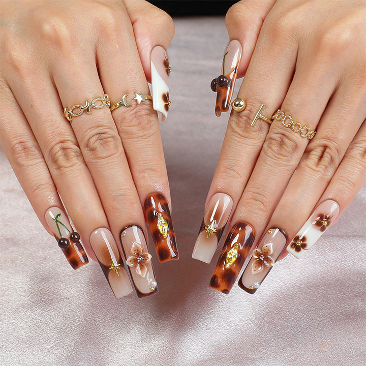 Elegantes Nagelkunstset mit floralen und goldenen Akzenten Karnz