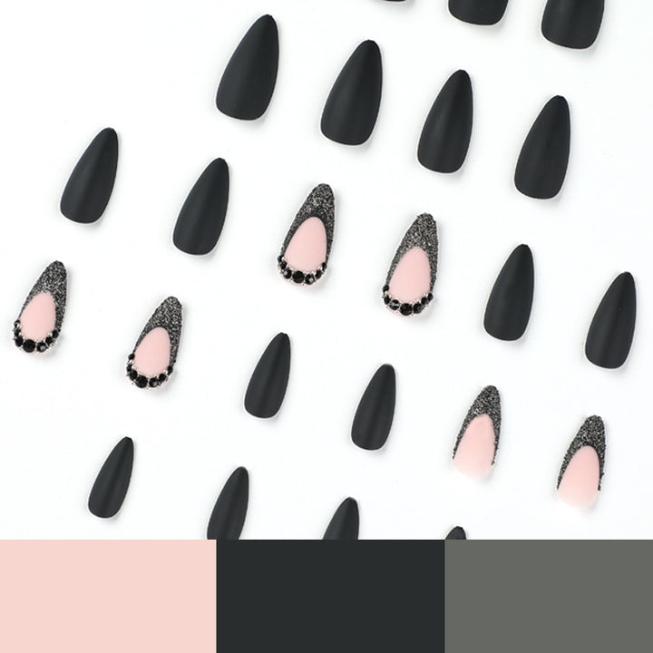 Kunstvolle Stiletto-Nägel mit elegantem Schwarz-Design und Glitzerakzenten Karnz