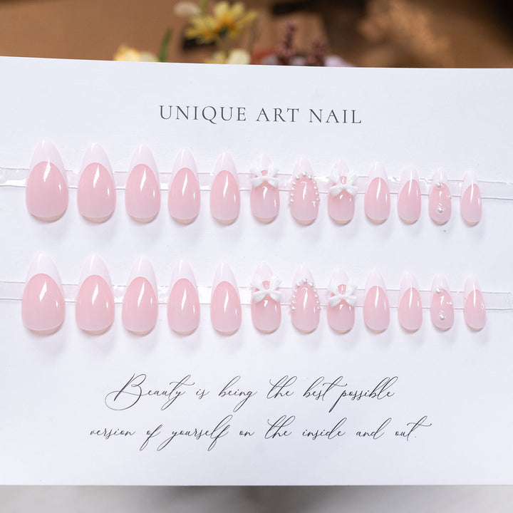 Dekorative Press-On-Nagelkunst mit Schleifenakzenten