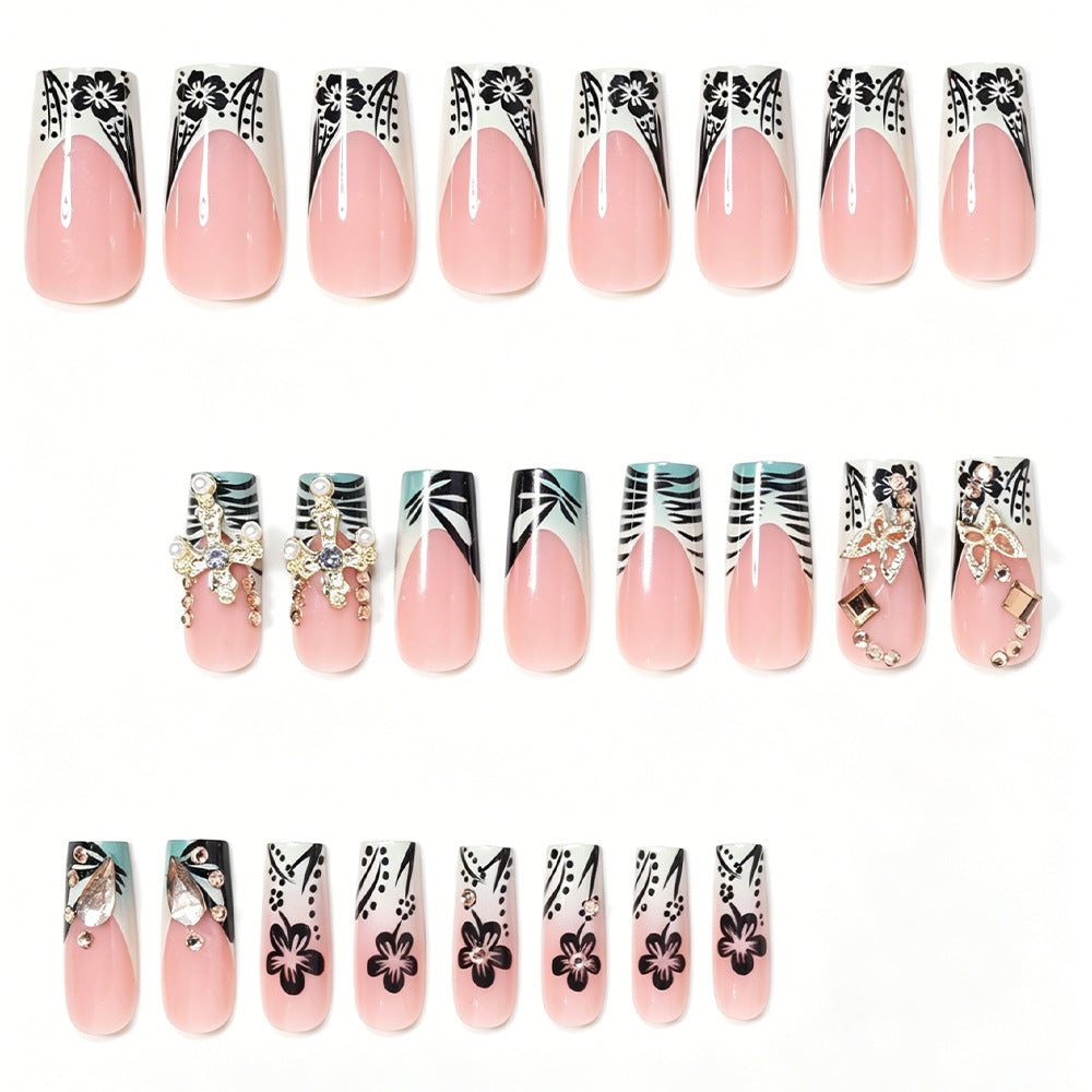Künstlerisches Stiletto-Nageldesign mit floralen Akzenten und Edelsteinen Karnz