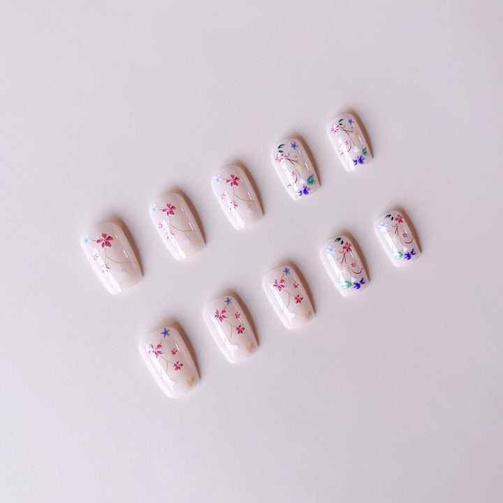 Kunstnagelset mit floralen Akzenten und transparentem Glanz Karnz
