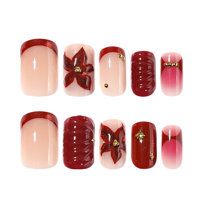Kunstvolle Nagelgestaltung mit floralen und goldenen Akzenten Karnz