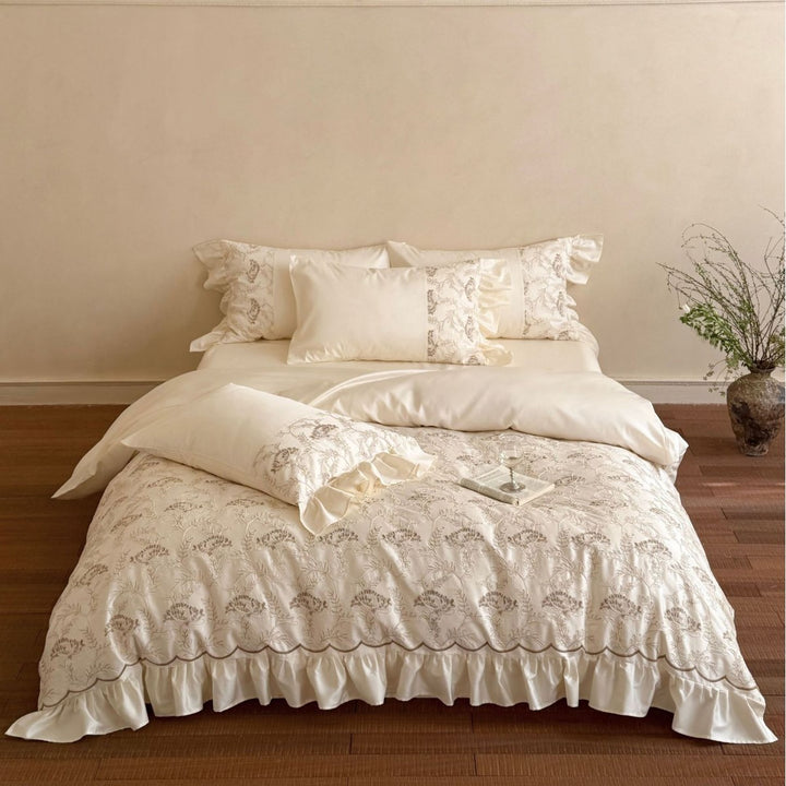 Steppbett mit floraler Stickerei, Satinvolant und dekorativer Biese