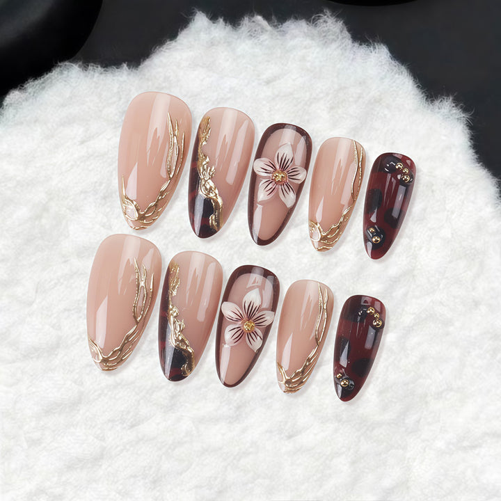 Dekorative Stiletto Press-On Nägel mit floralen und goldenen Akzenten Karnz
