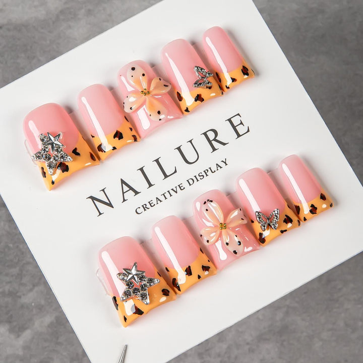 Dekoratives Press-On Nagelset mit floralen und Schmuckakzenten