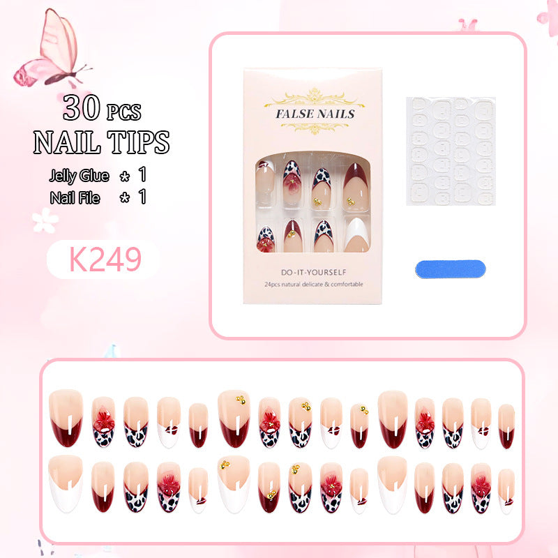 Kunstnagelset mit eleganten floralen Mustern und glamourösen Details Karnz