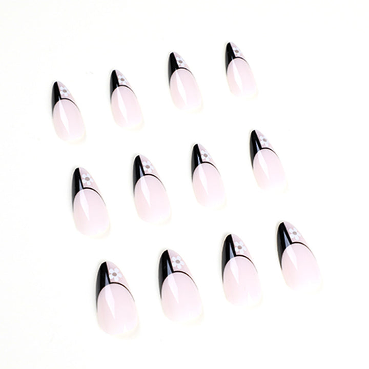 Kunstvolle Nagelkunst mit eleganten Schwarz-Weiß-Design und floralen Akzenten Karnz