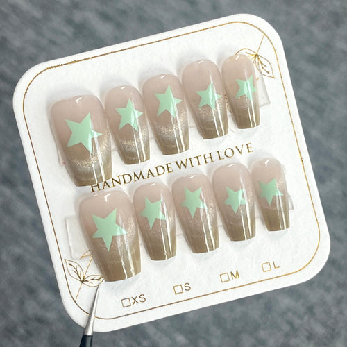 Künstliche Nagelverlängerungen mit Shimmer-Effekt und Sternenmotiven Karnz
