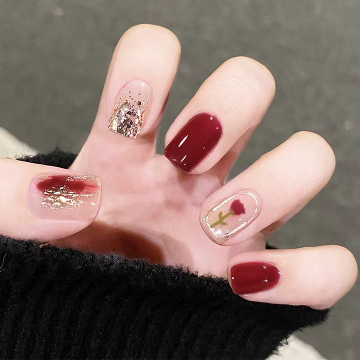 Elegantes Nageldesign mit floralen und glitzernden Akzenten Karnz
