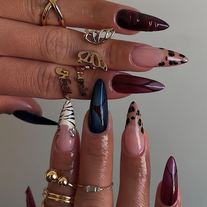 Künstlerische Stiletto-Nagelverlängerungen mit trendigem Tierdruck und Schmuckakzenten Karnz