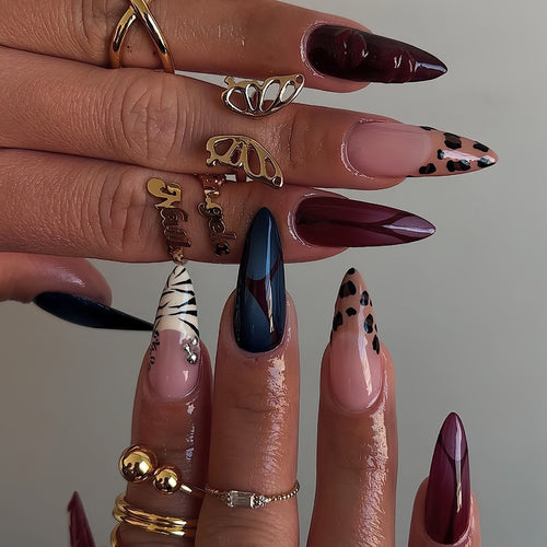 Künstlerische Stiletto-Nagelverlängerungen mit trendigem Tierdruck und Schmuckakzenten Karnz