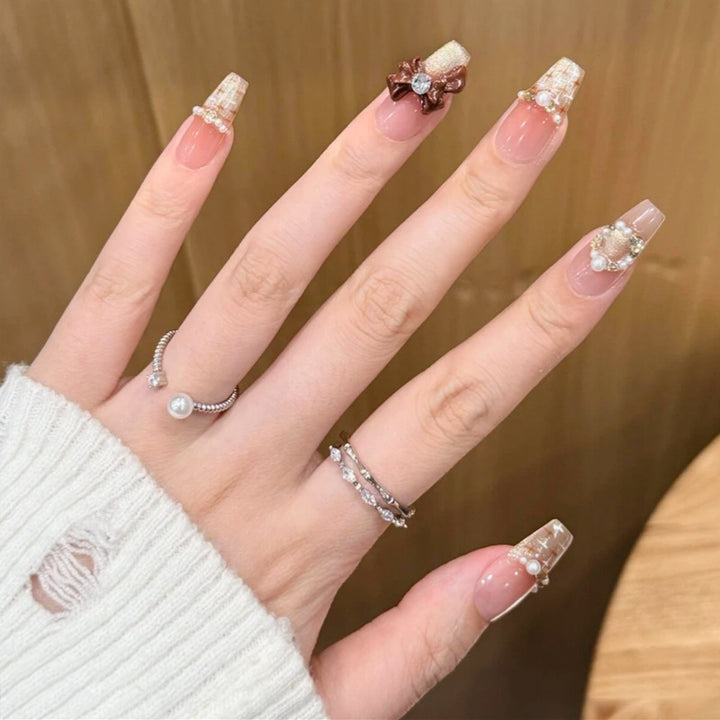Kunstnagelset mit eleganten Applikationen Karnz