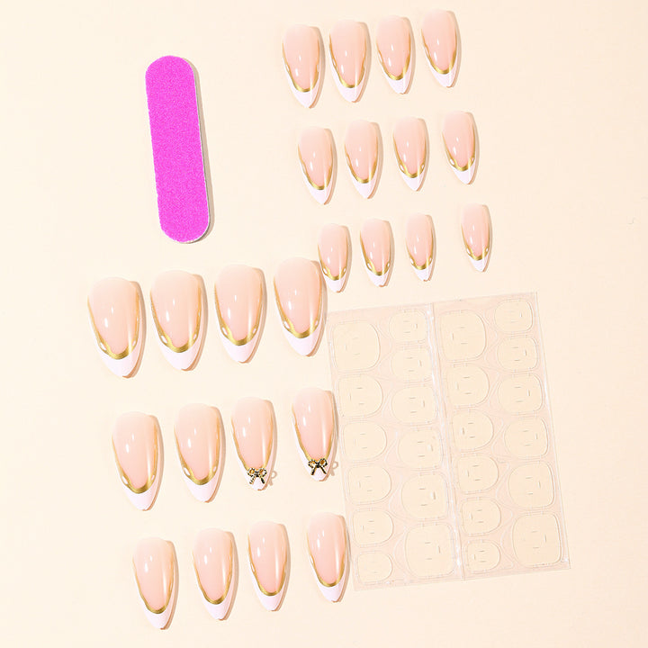 Elegante French Tip Nagelverlängerungen mit goldenen Akzenten Karnz