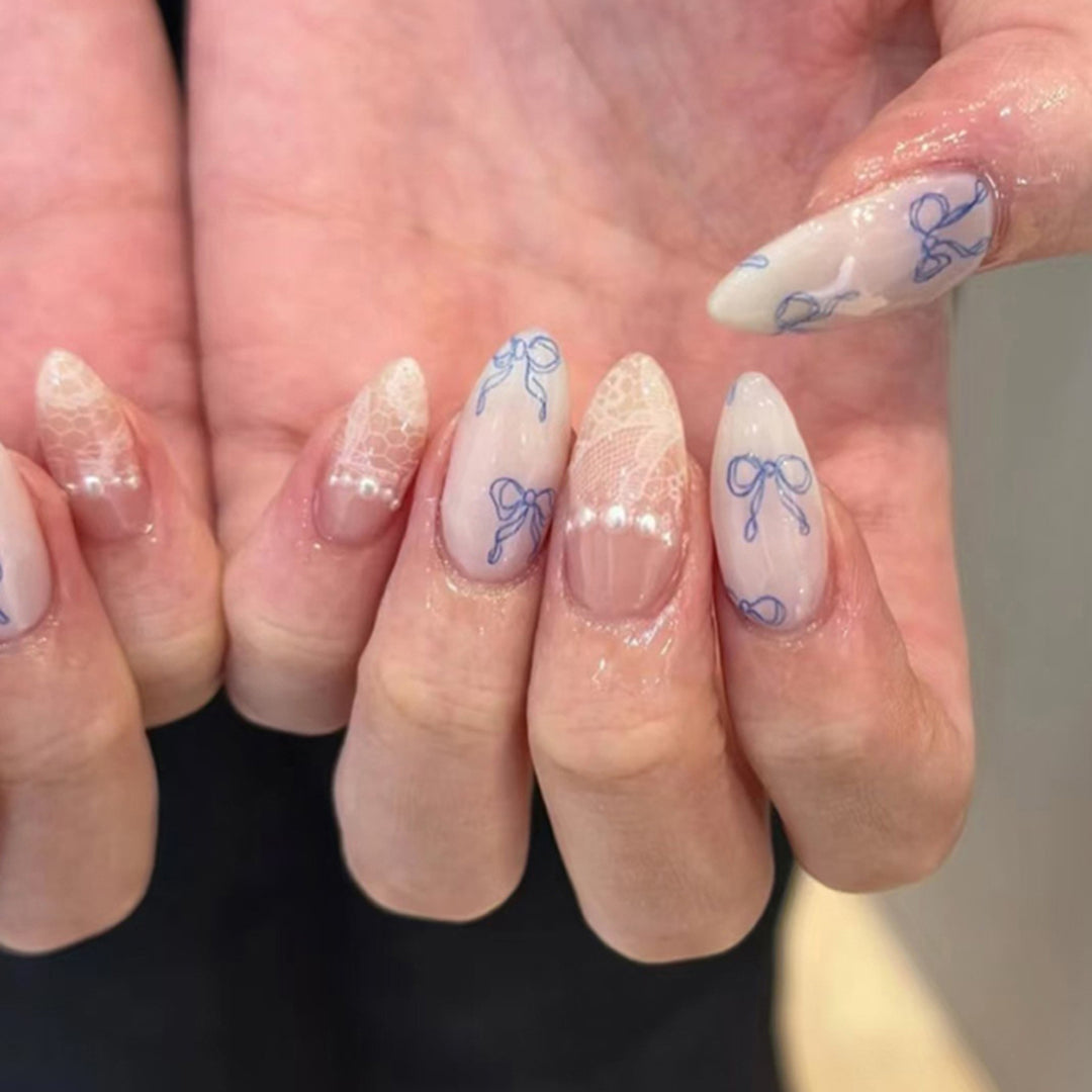 Kunstvolle Stiletto-Nägel mit zarten Schleifenverzierungen Karnz
