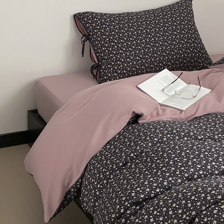 Wendbare Bettwäsche‑Garnitur aus Baumwollsatin mit feinem Blumenallover, kontrastierter Innenseite und dekorativen Schleifen