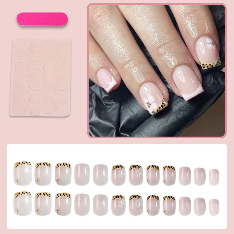 Kunstnagelset mit eleganter französischer Spitze und floralem Akzent Karnz