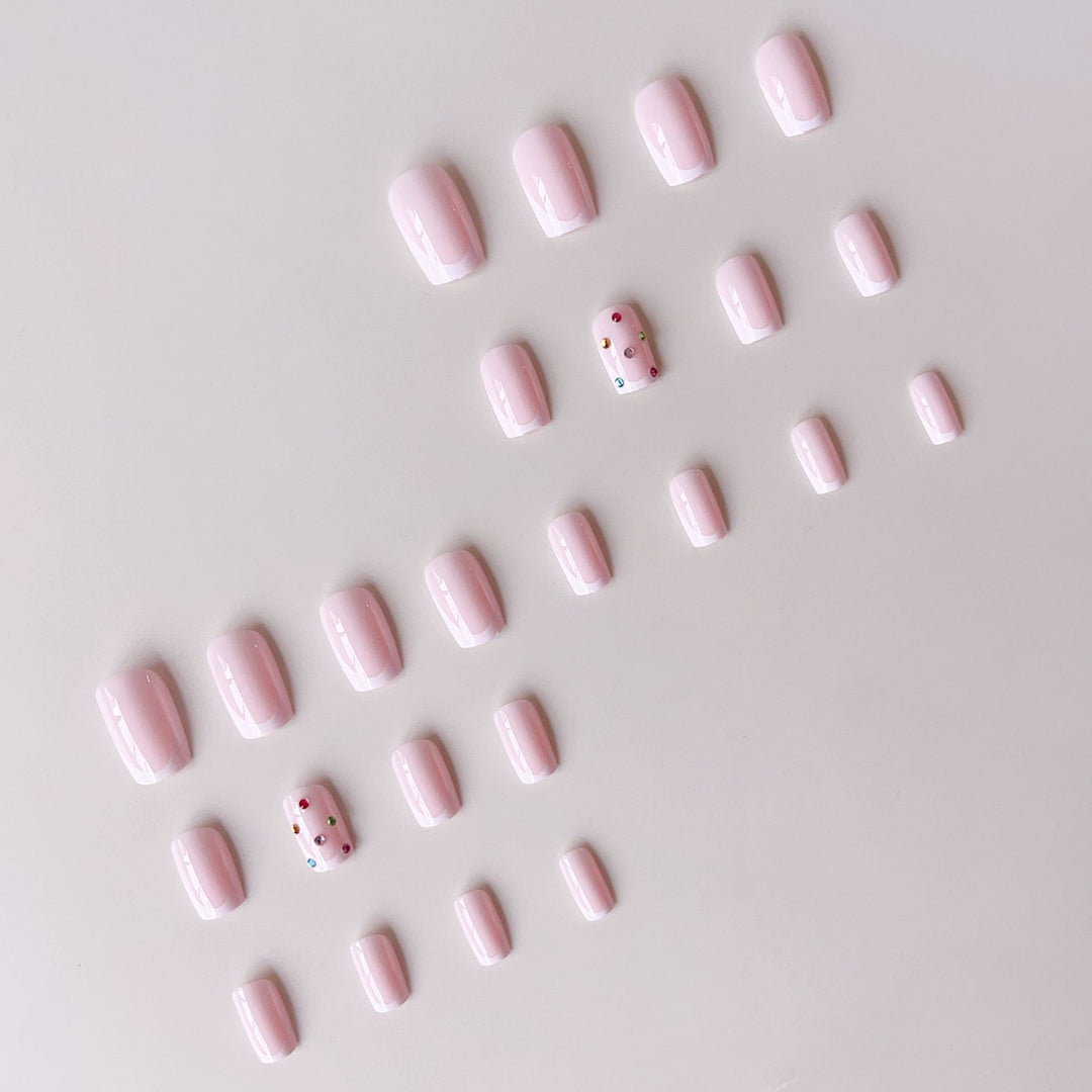Nagelkunstset mit eleganten French-Spitzen und funkelnden Strassverzierungen Karnz