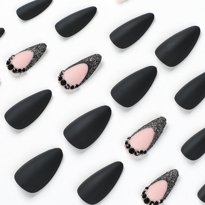 Kunstvolle Stiletto-Nägel mit elegantem Schwarz-Design und Glitzerakzenten Karnz