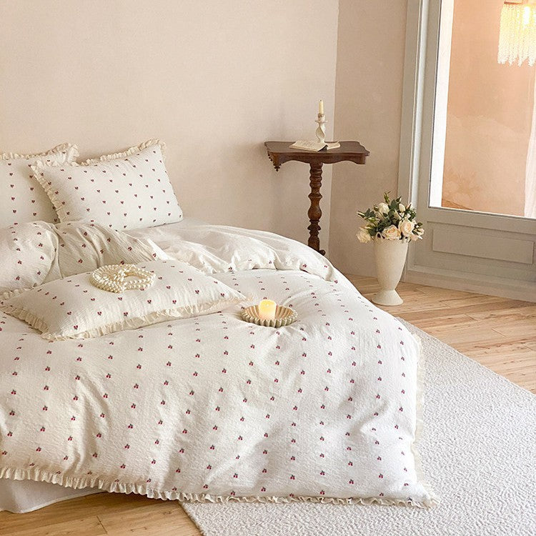 Gestepptes Bettwäscheset aus Baumwoll‑Musselin mit zartem Kirschenprint und Rüschenkante
