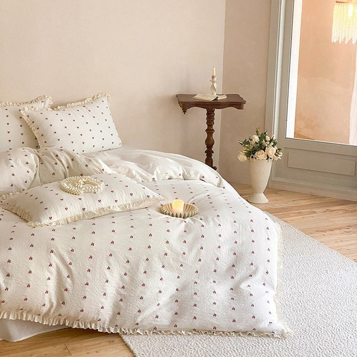 Gestepptes Bettwäscheset aus Baumwoll‑Musselin mit zartem Kirschenprint und Rüschenkante