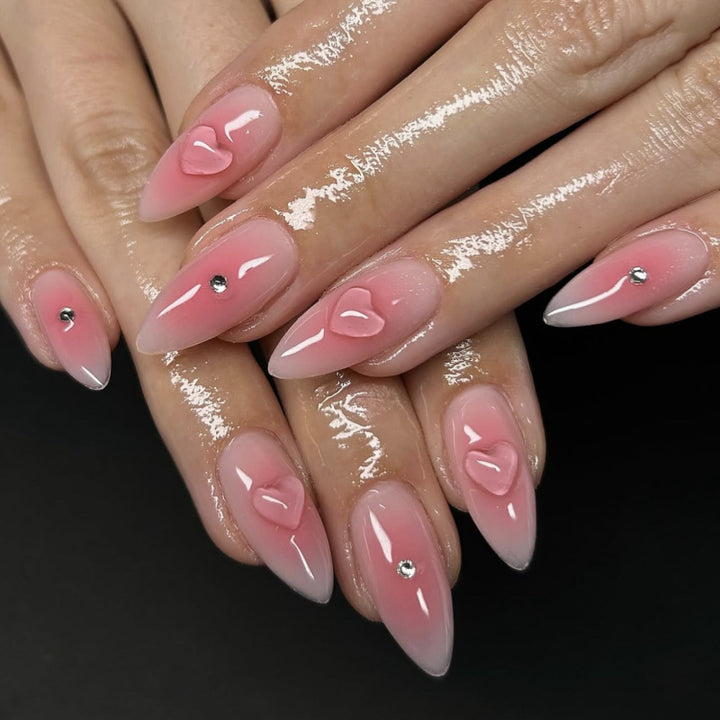 Kunstvolle Stiletto-Nägel mit Herzdesign und Glitzerakzenten Karnz
