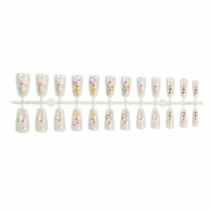 Kunstnagelset mit floralen Verzierungen und glamourösen Details Karnz