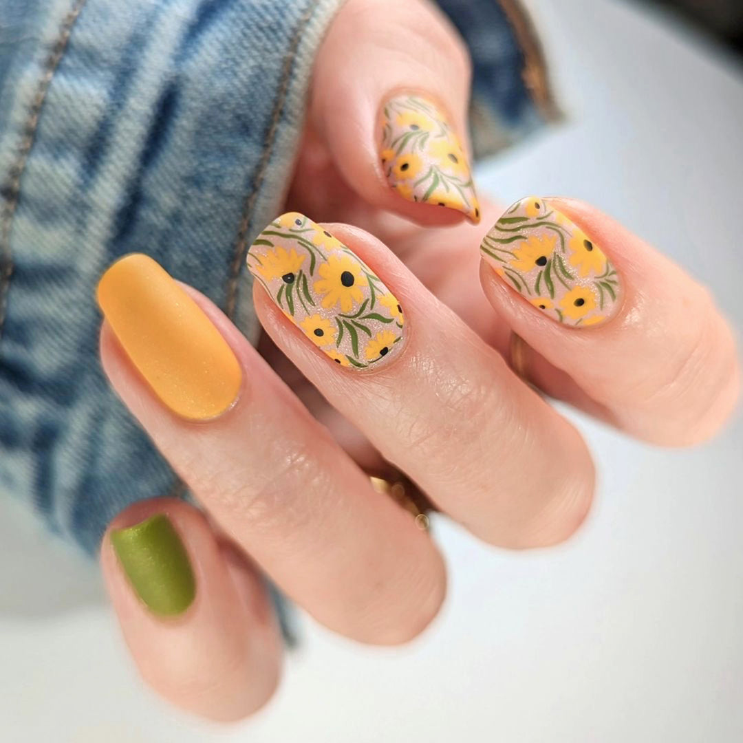 Kunstvolle Nagelverlängerungen mit floralen Designs und kreativen Farbakzenten Karnz