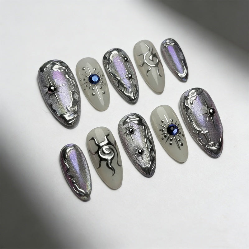 Kunstnagelset mit glänzendem Metallic-Effekt und eleganten Verzierungen Karnz