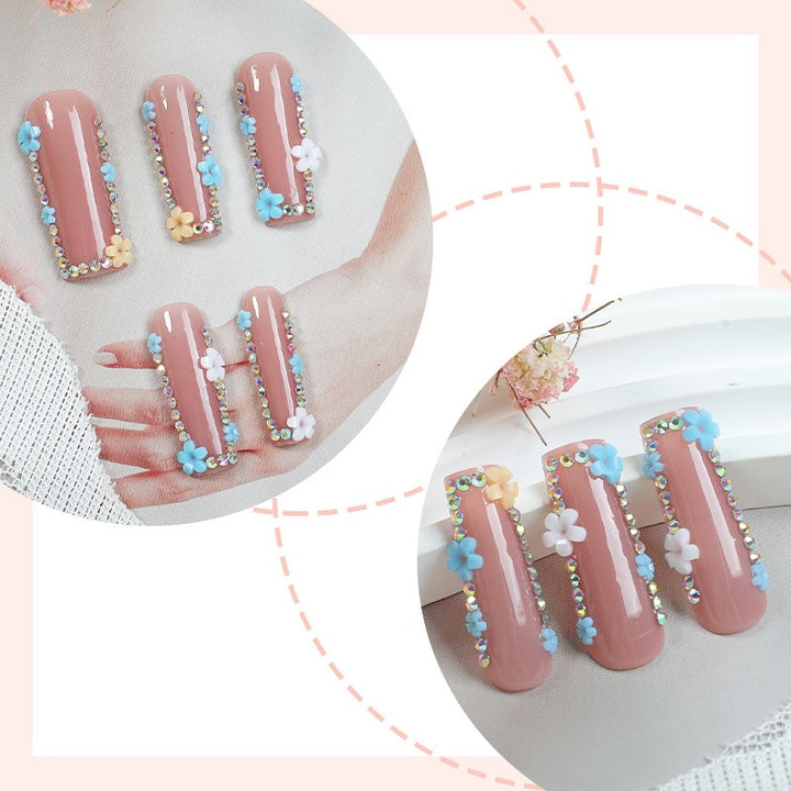 Kunstnagelset mit zarten Blumenverzierungen und Glitzerakzenten Karnz