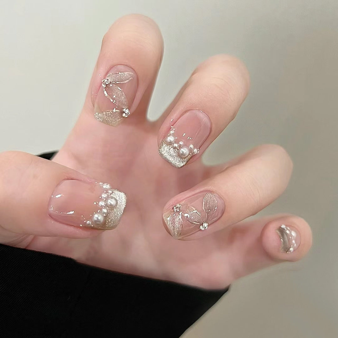 Elegante Kunstnägel mit Perlenschmuck und Glitzereffekten Karnz