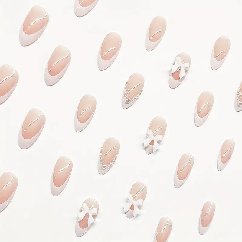 Künstlerisches Press-On-Nageldesign mit Schleifenakzenten Karnz