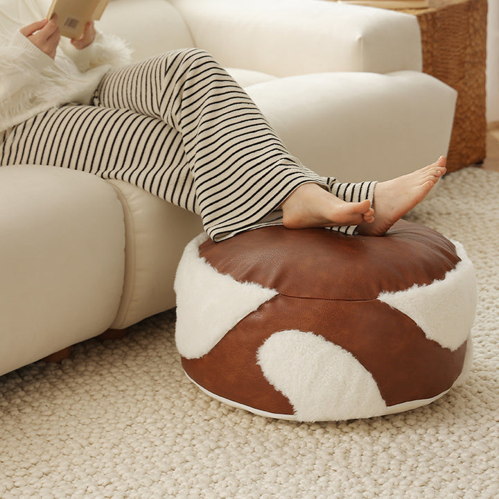 Runde Sitzpouf mit Kunstlederbezug und Sherpa‑Applikationen