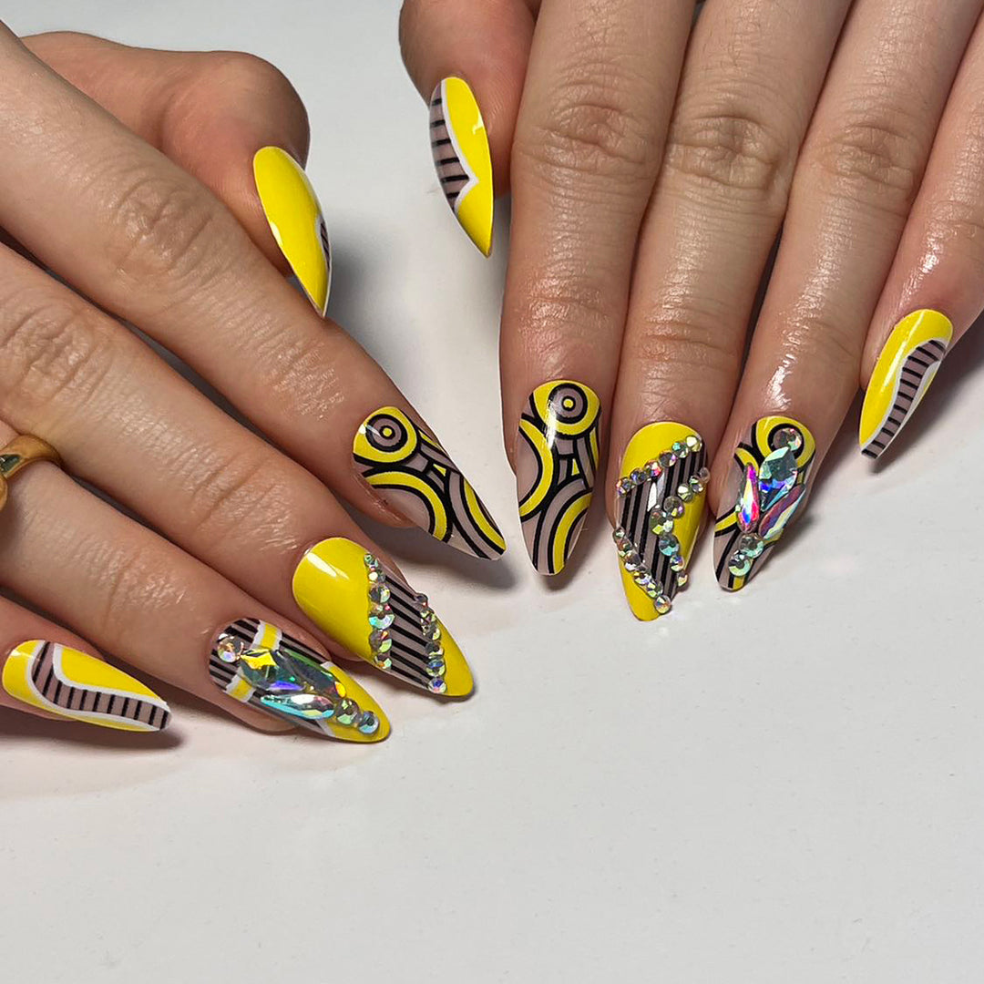Kunstvolle Nagelverlängerungen mit geometrischem Design und Glitzerakzenten Karnz