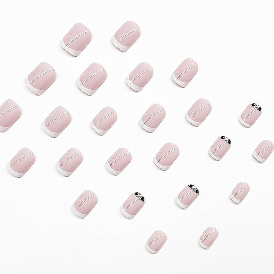 Kunstnagelset mit elegantem französischen Design und glitzernden Akzenten Karnz