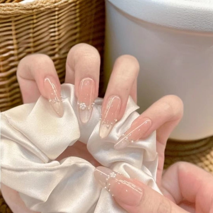 Dekorative Acryl-Nagelerweiterungen mit perlmuttartigen Akzenten
