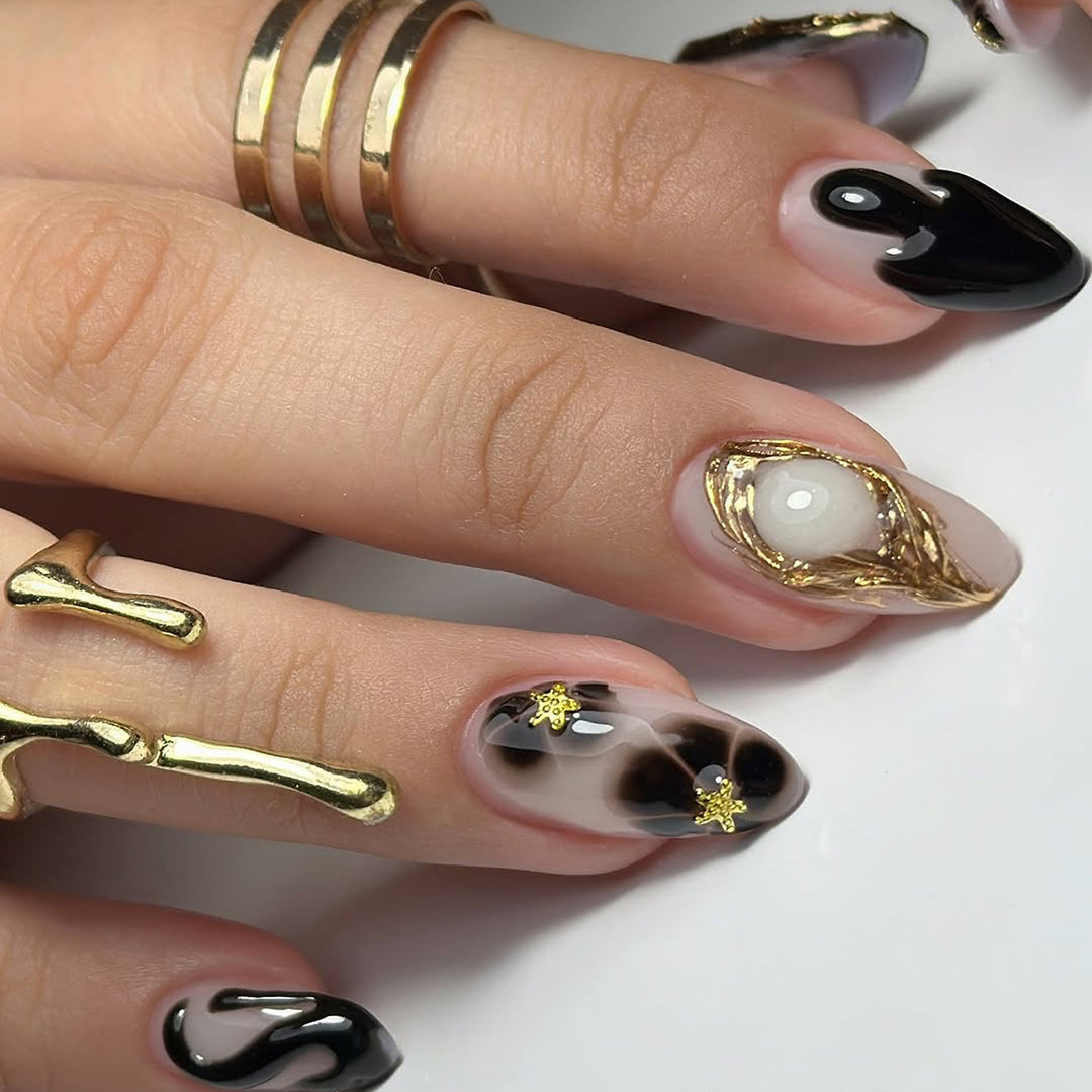 Elegante Stiletto-Kunstnägel mit Goldakzenten und modernen Designs Karnz