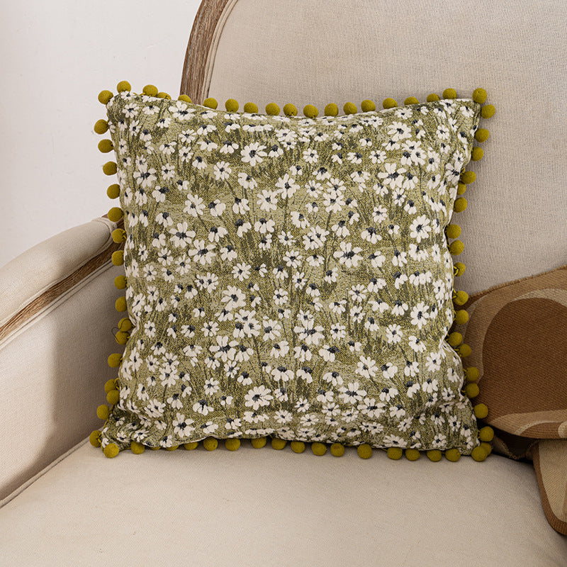Dekoratives Wurfkissen mit floralen Pom-Poms