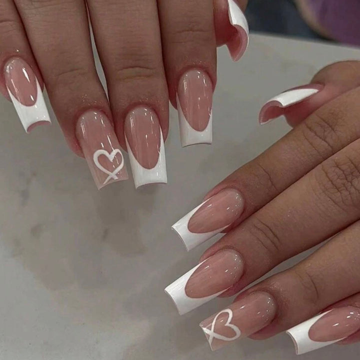 Kunstnagelset mit eleganten French Spitzen und romantischen Herzverzierungen Karnz