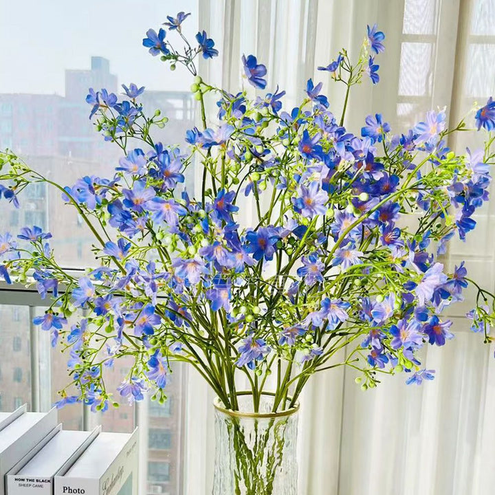 Künstliches Blumenarrangement mit dekorativer Glasvase