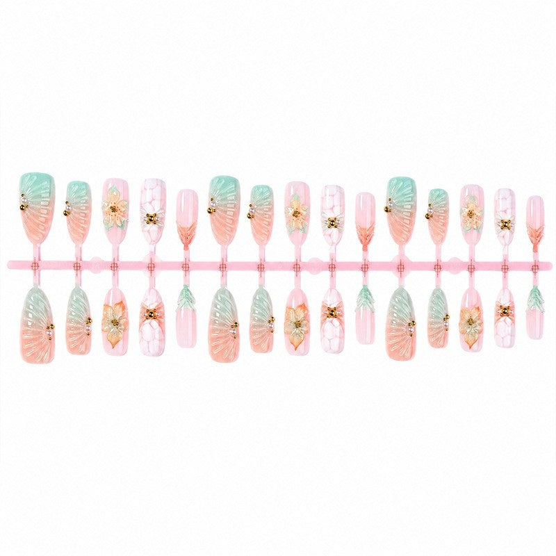 Kunstnagelset mit glamourösen Blumen- und Glitzerdetails Karnz
