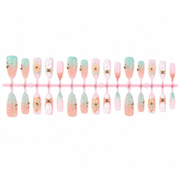 Kunstnagelset mit glamourösen Blumen- und Glitzerdetails Karnz