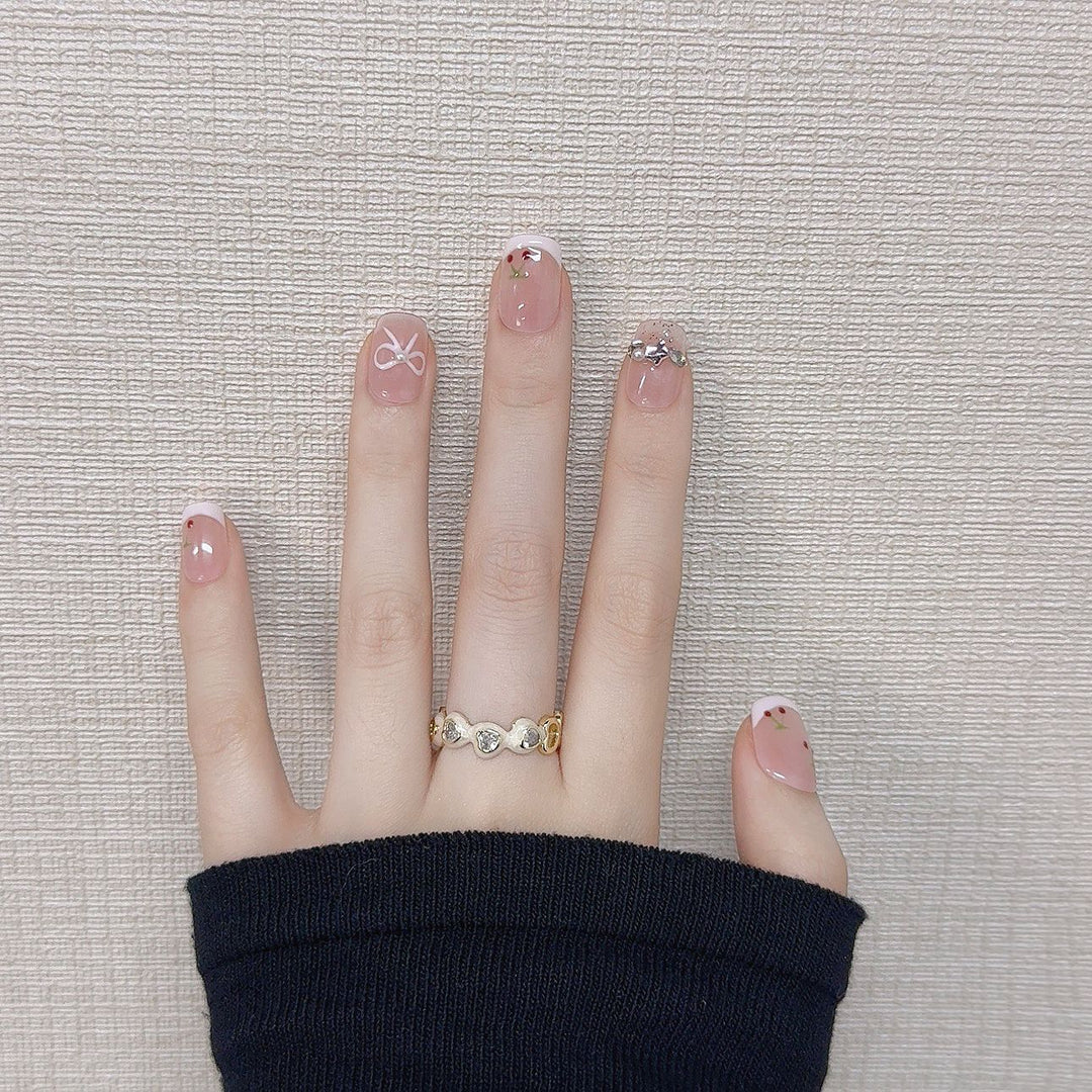 Dekorative Press-On-Nagelkunst mit floralen und Schleifenakzenten