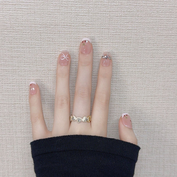 Dekorative Press-On-Nagelkunst mit floralen und Schleifenakzenten